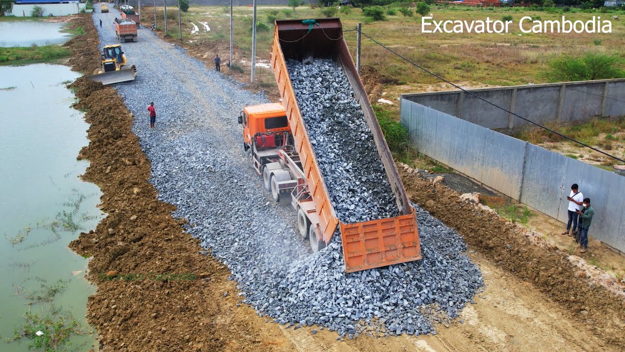 Dozer Pushing Rock Reshaping And Making Terraces For Foundation New Road And Dump Trailer Unloading