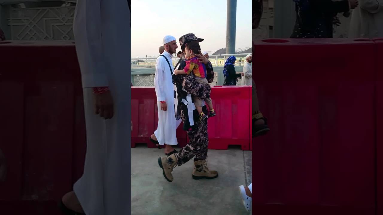 عسكري سعودي يساعد حاج مصري ويحمل طفله