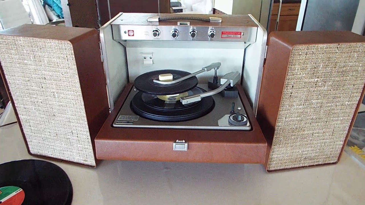 GE portable stereo record player playing a stack of 45's