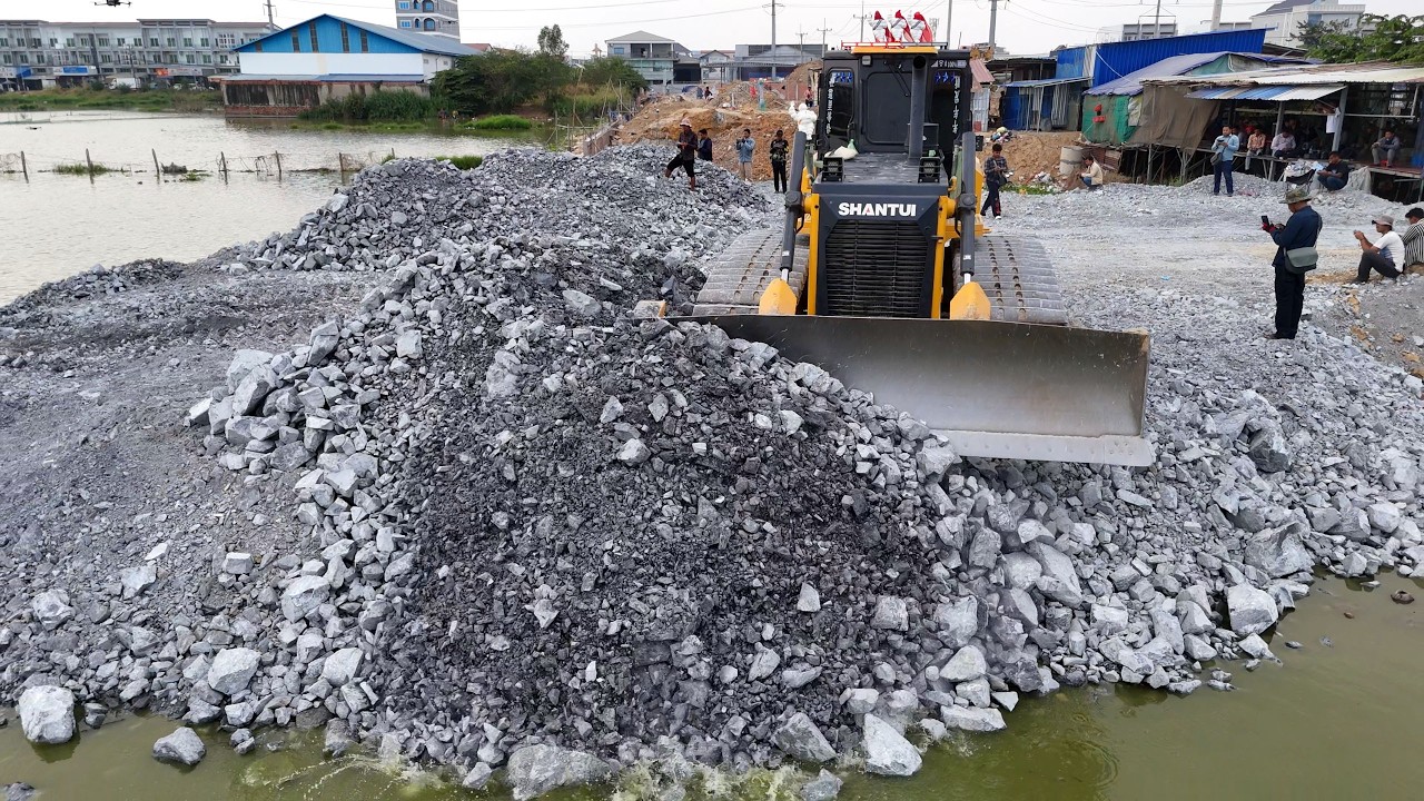 Skilled operation in action! Using SHANTUI C3 Dozer and 10-Wheel Dump Trucks to fill flooded land.