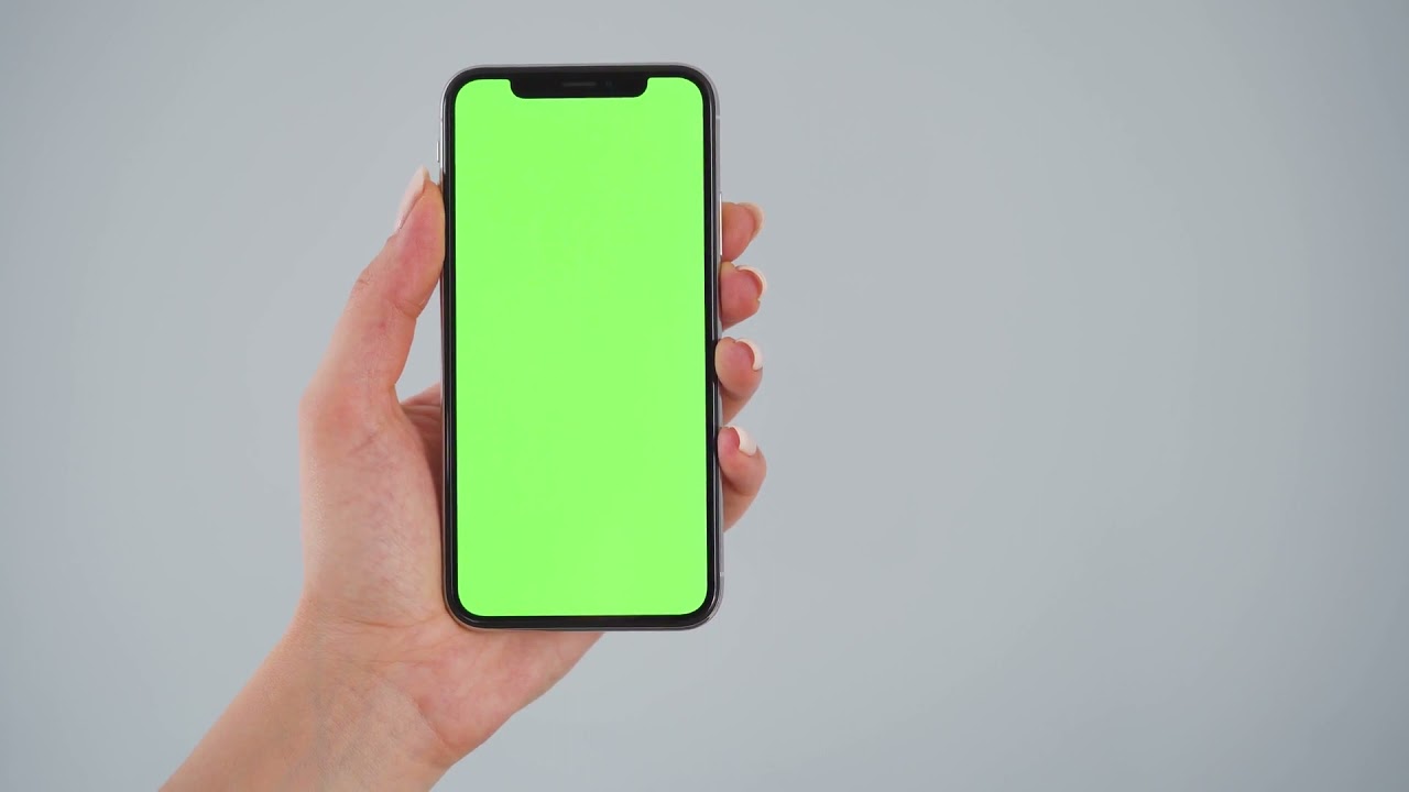 female hands holding a smartphone with a green screen