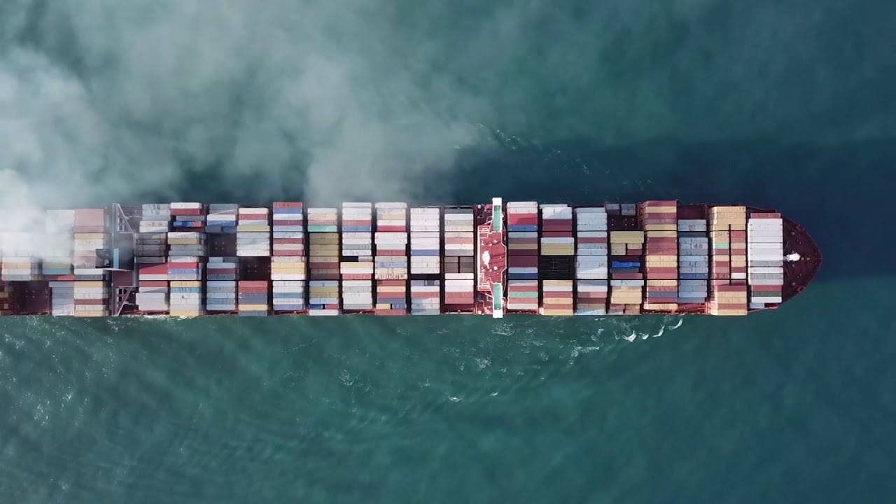 DRONE FLYING OVER SHIP with containers in the ocean