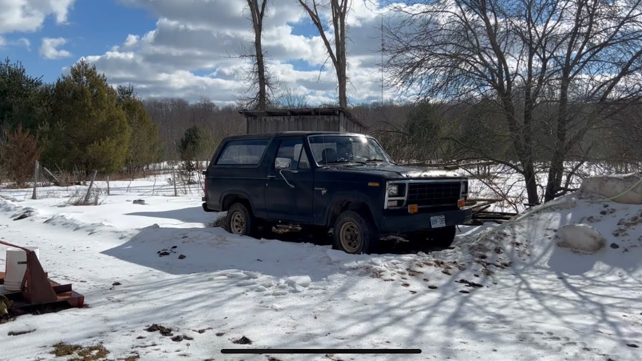 1980 Ford Bronco driving in snowy fields