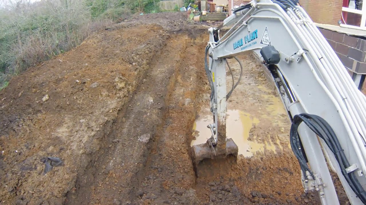 Shaping a garden with a digger Takeuchi TB260 Excavator