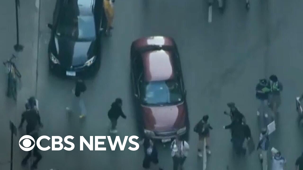Car speeds through ICE protest crowds in Chicago