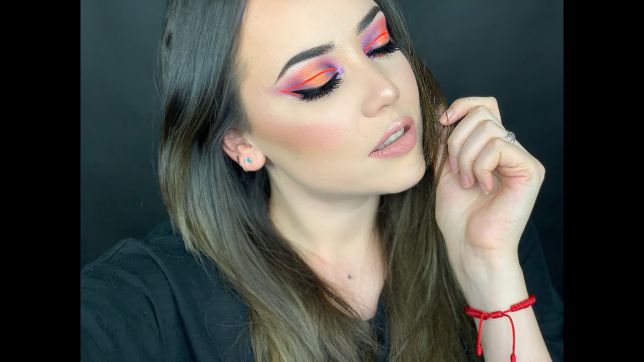 Maquillaje en tonos morado, naranja y... un delineado neon rosa?