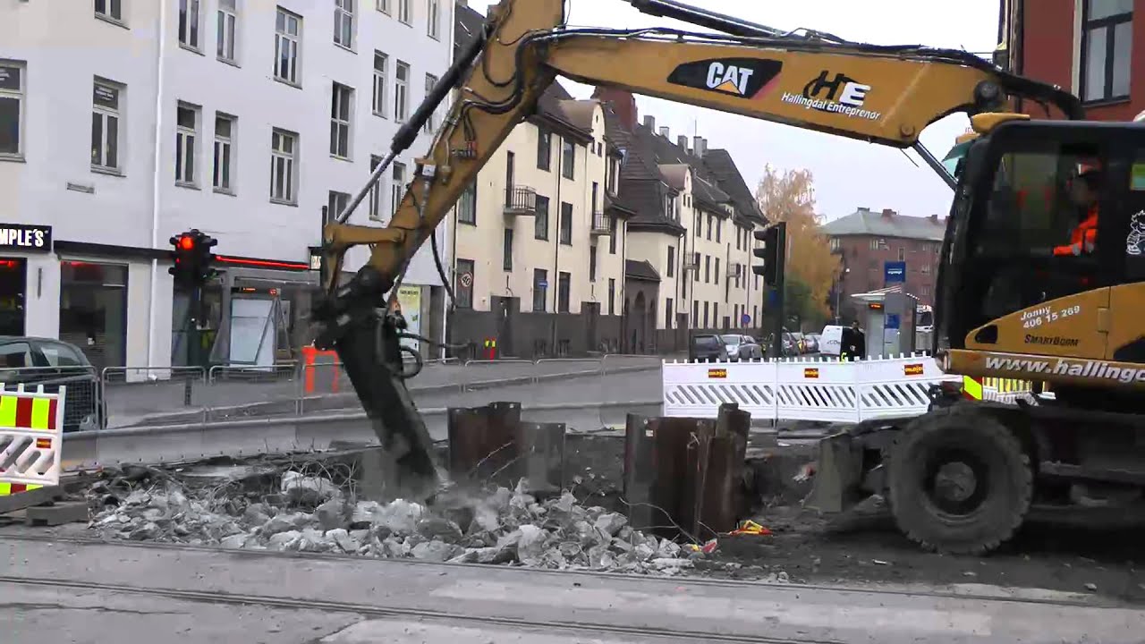 Cat M316D Wheeled Excavator Hammering Concrete