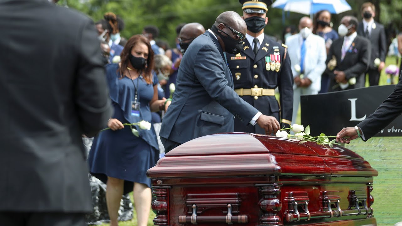 Roses placed on John Lewis' casket at cemetery, doves released