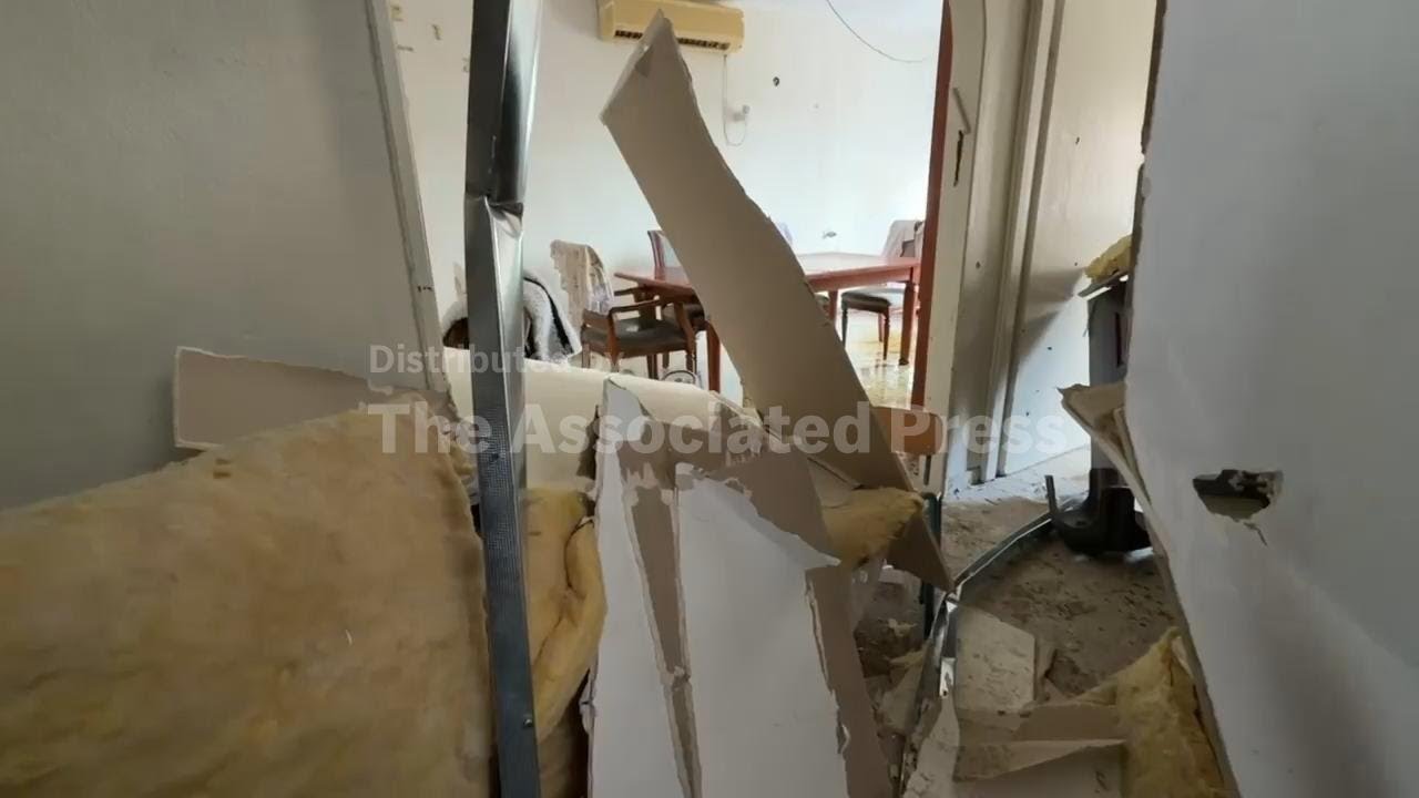 Rescuers and civilians inspect damage at impact site in central Israel after Iran attack
