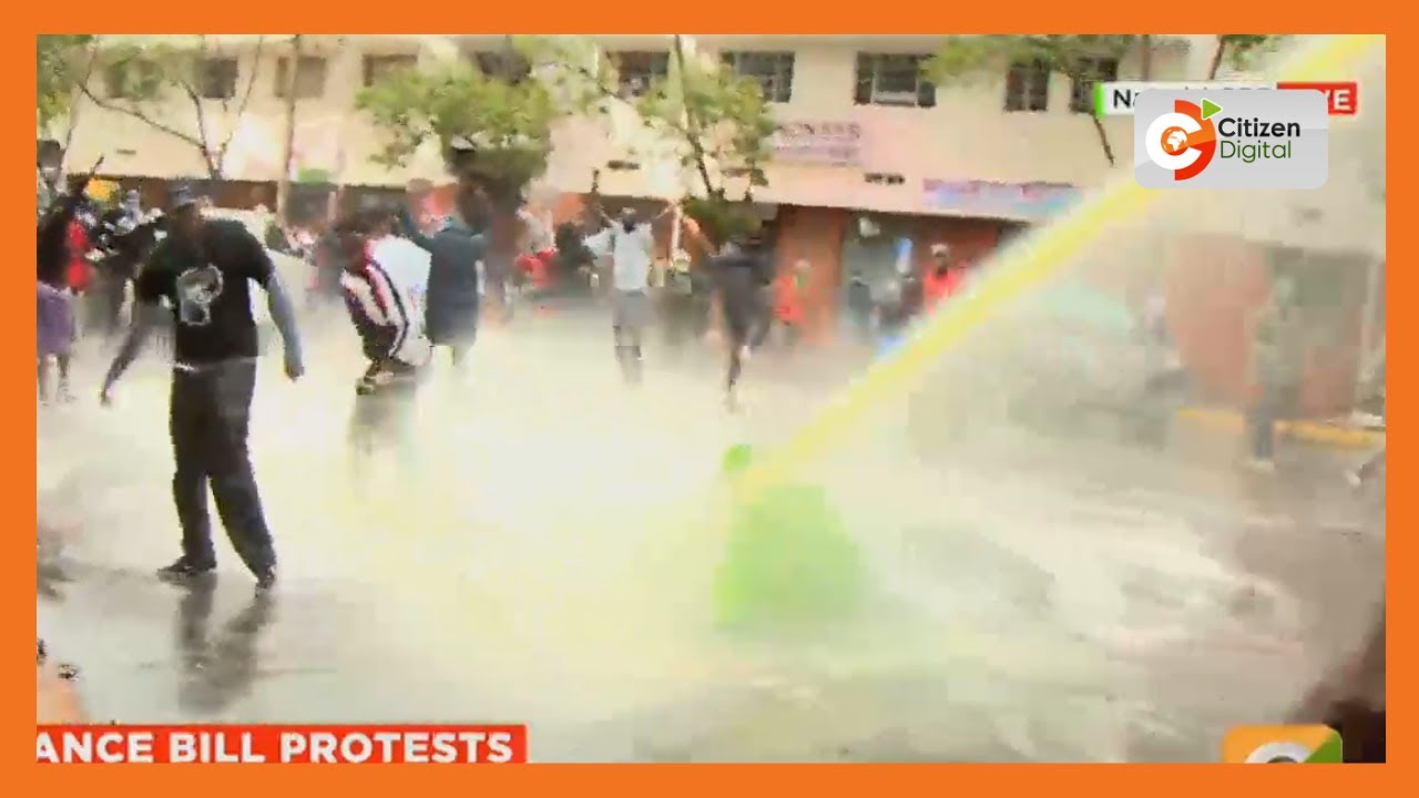 Protester taunting anti-riot police knocked to the ground by a water canon blast