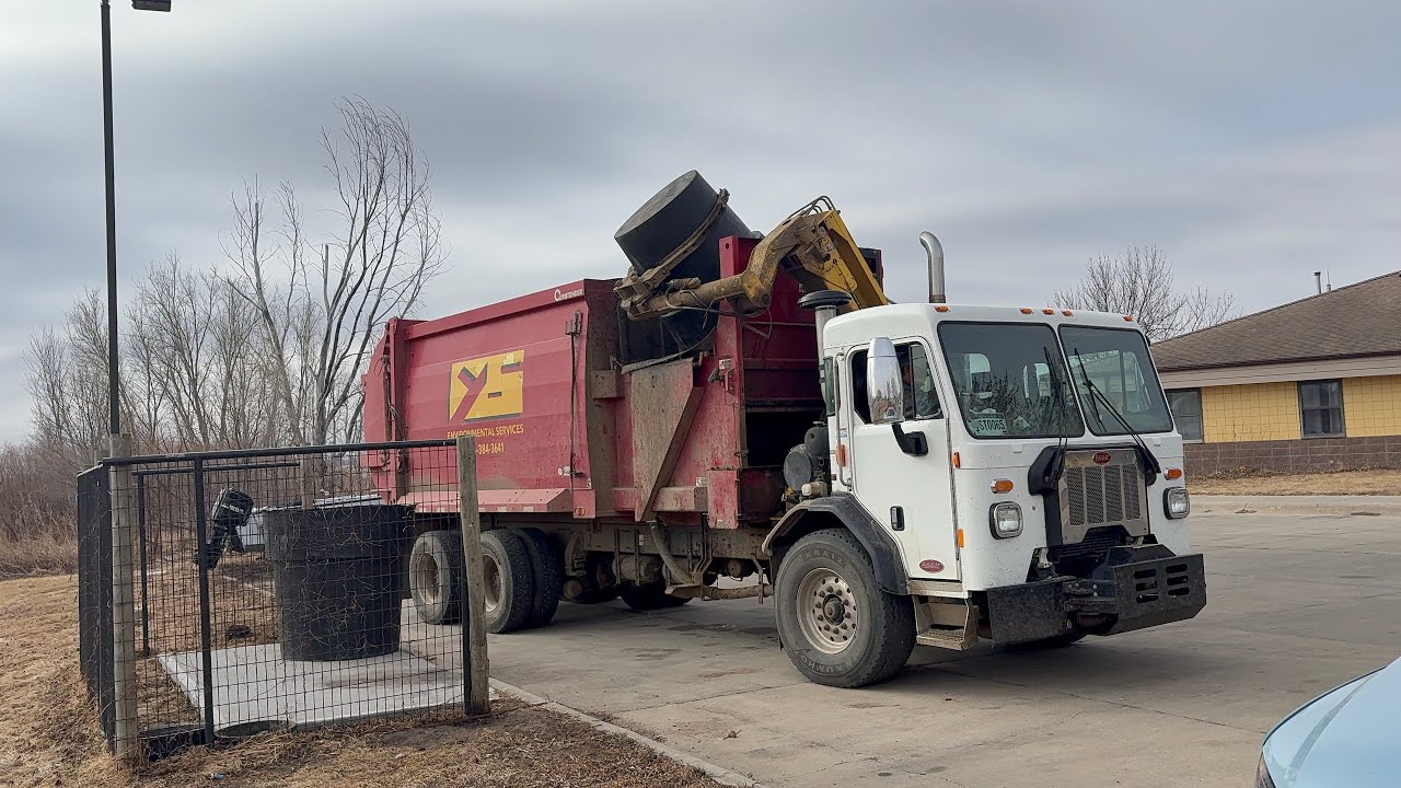 Yankton Sioux Tribe garbage truck- Peterbilt Wayne Curbtender side loader on heavy trash 