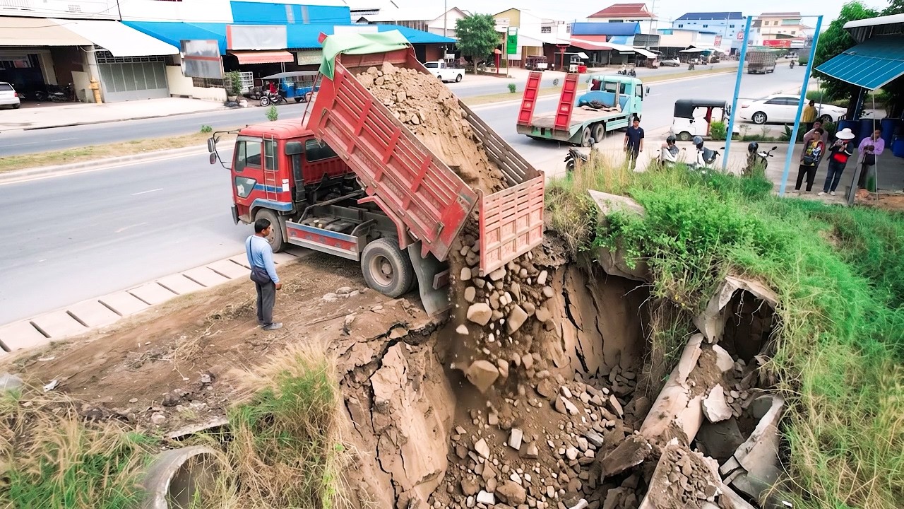 Heavy Dump Truck Unloading Soil to Fill a Deep Hole / Trench