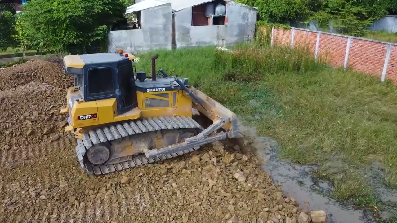 Nearby connect wall complete 100% by SHANTUI DH17 C3 pour stone delete pit field with dump truck