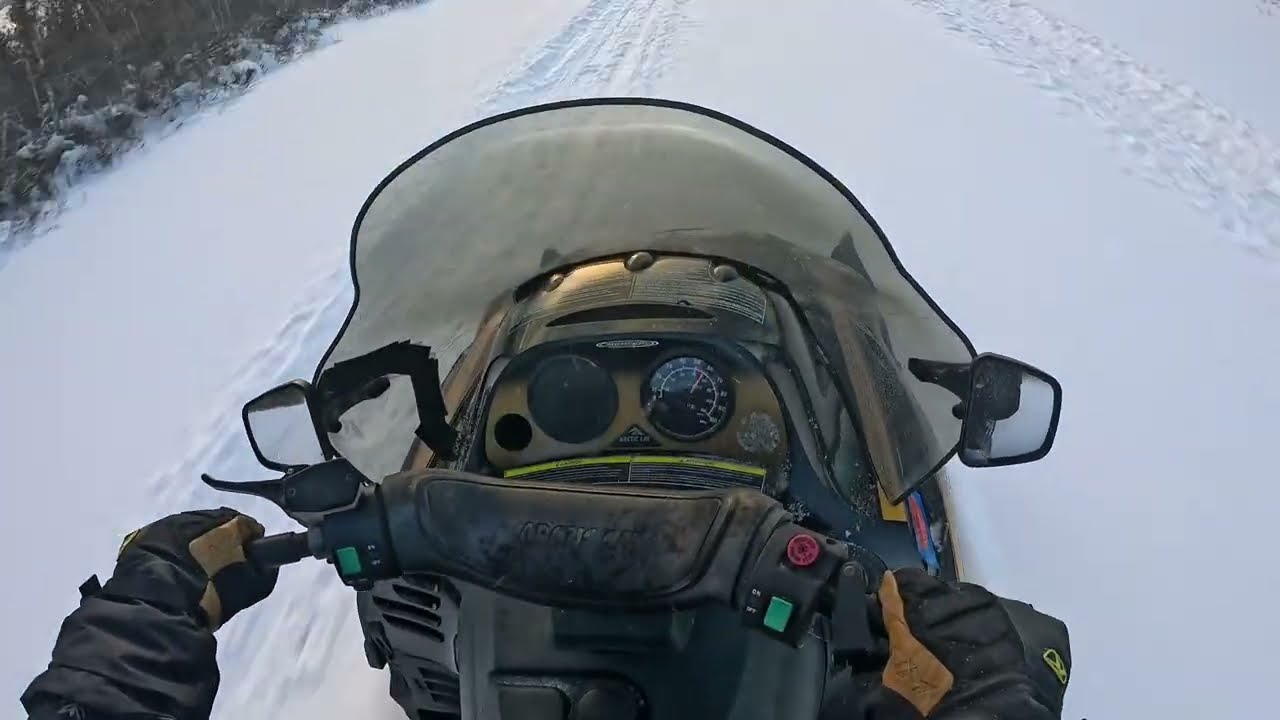 Snowmobiling down a frozen stream 