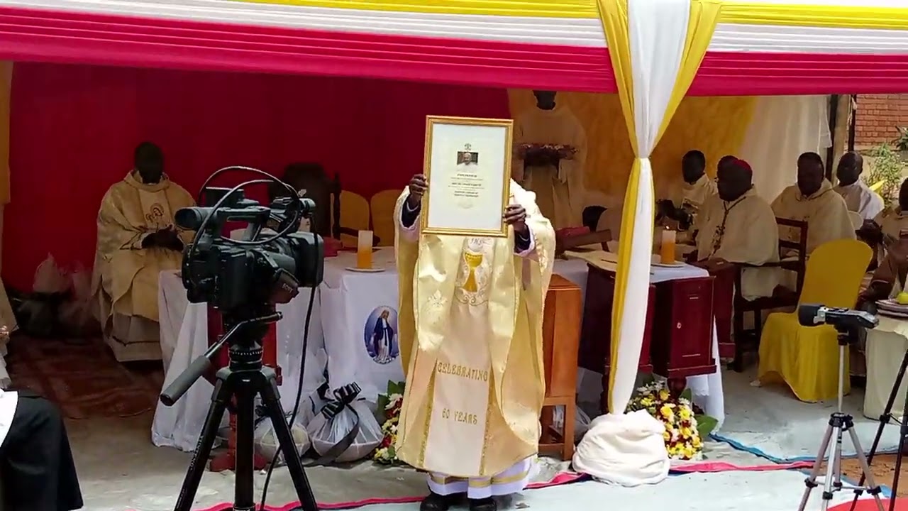 kiyinda ayinda #Rev Fr  James Kabuye shows off his Gift blessing from Pope Francis @60yrs Preistly a