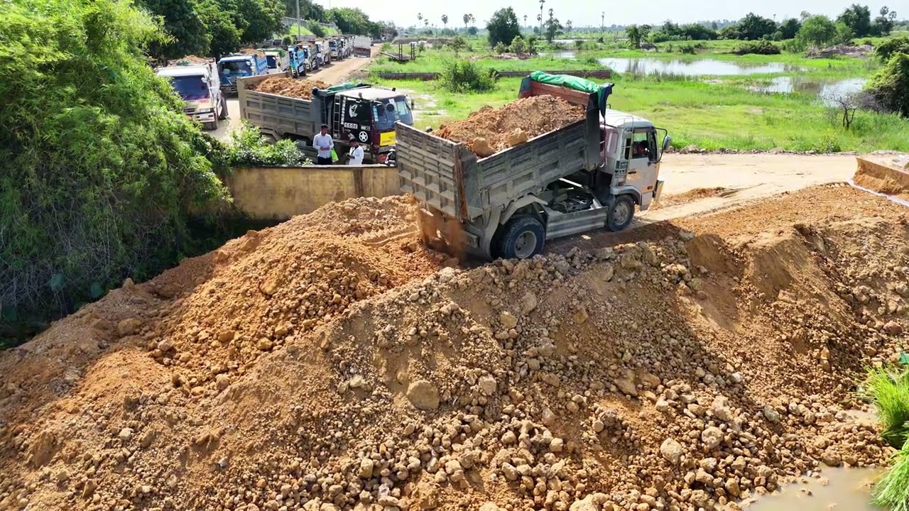 Wonderful landfill project with Komatsu D30P Bulldozer and many dump trucks lined up to unloading