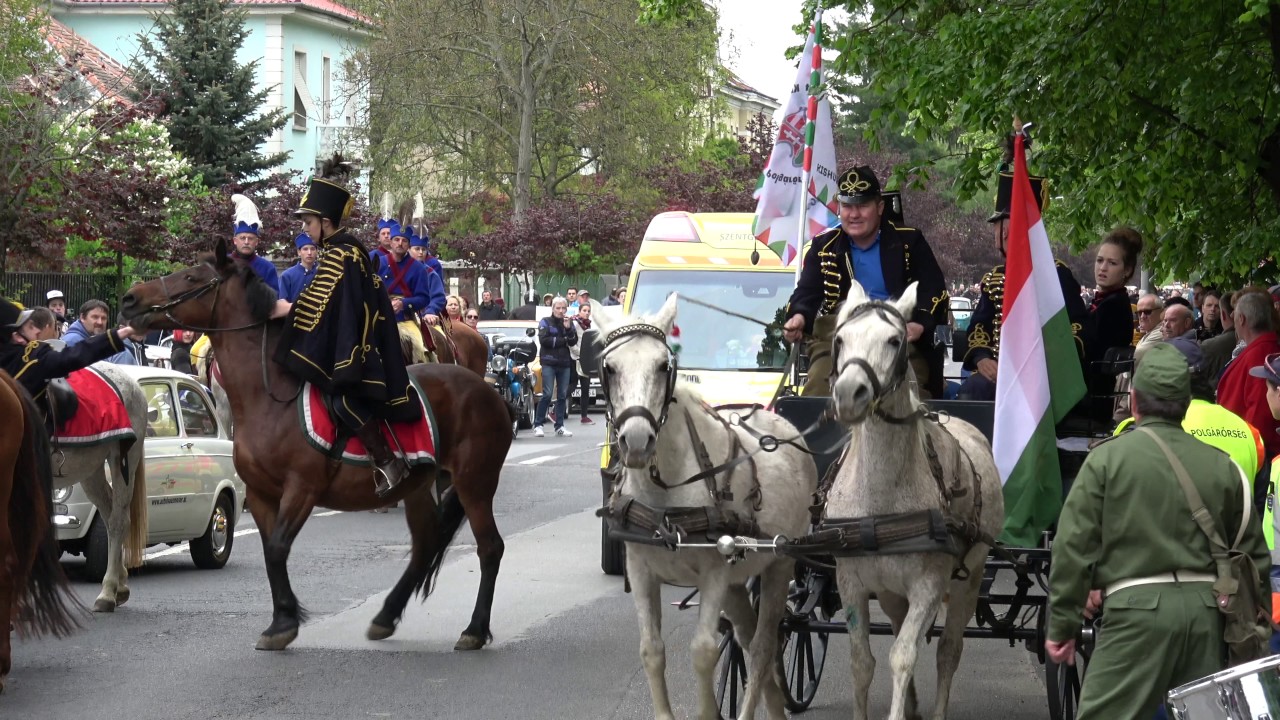 Szirénázó mentőautó hajt át a május elsejei retró felvonuláson