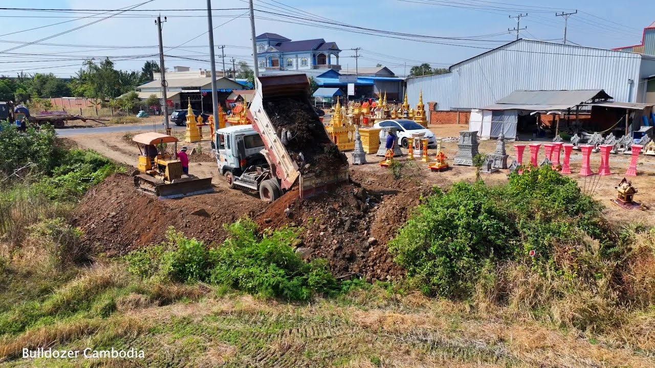 Full video project shows land filling up soil dozer komat'su D21P with a dump truck nissan 5 ton