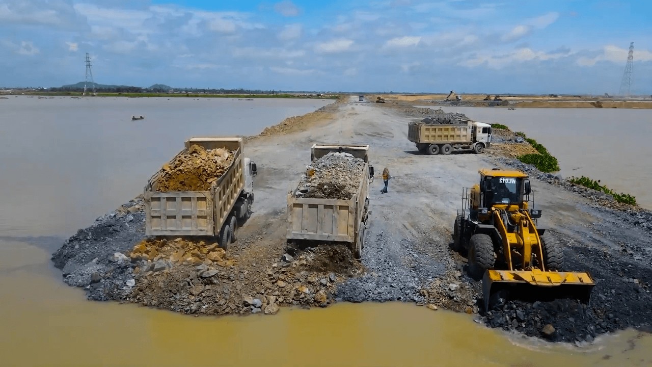 Operation Heavy Bulldozer and Dump Trucks Unloading Big Stone into Deep water Delete Heavy Lake