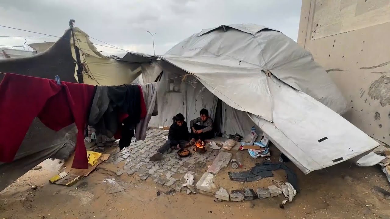 نازحون يحاولون تثبيت ما تبقى من خيامهم التي اقتلعتها الرياح في مدينة غزة