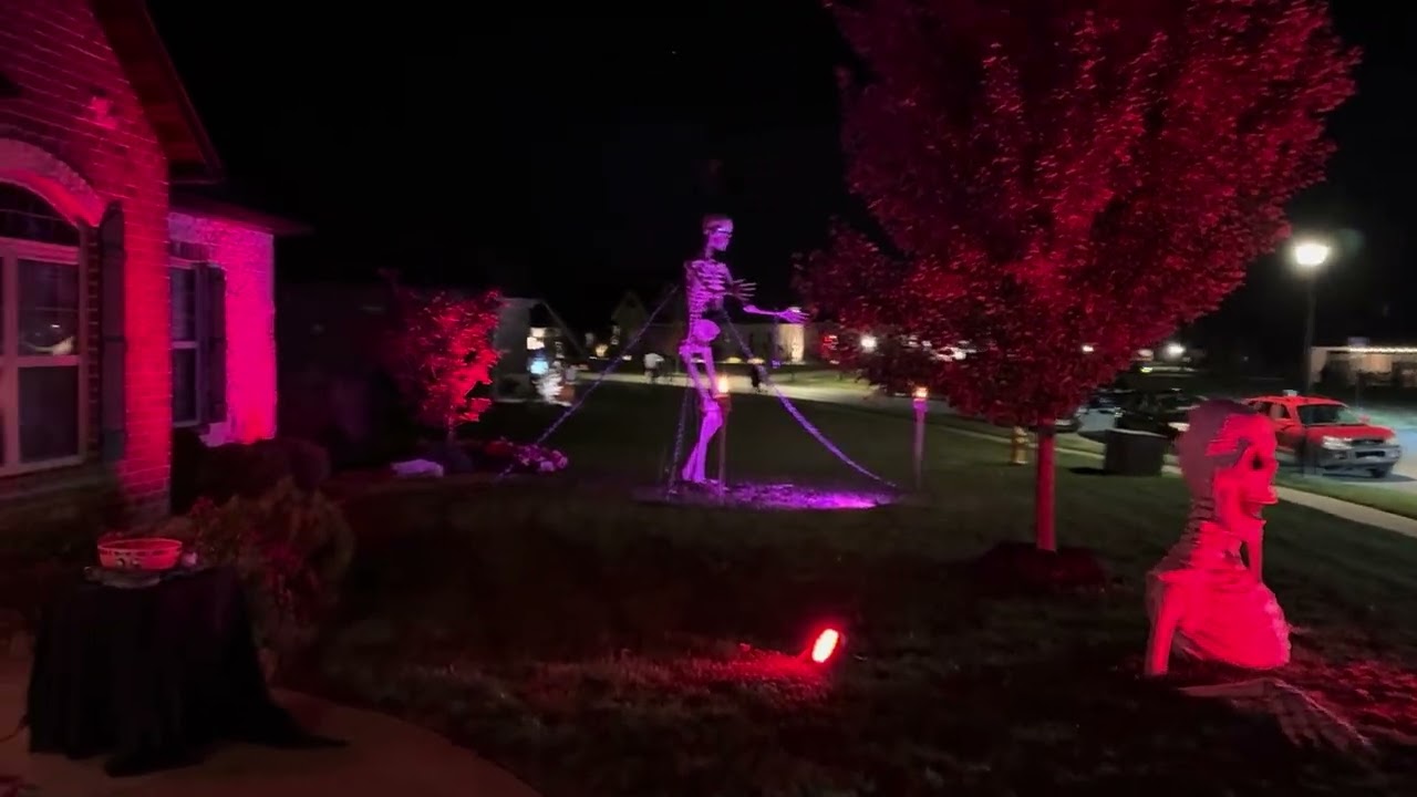 Halloween setup - tiki torch skulls, 12 ft skeletons, and groundbreaker skeleton.