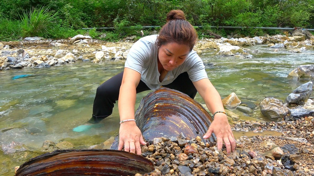 The girl found a group of clams in the clear water. When you open it, everything is top-notch pearls