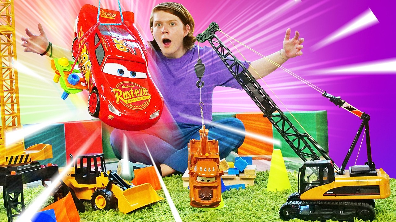 Une attraction avec une grue pour les voitures jouets. Jeux sur le chantier. Pour enfants