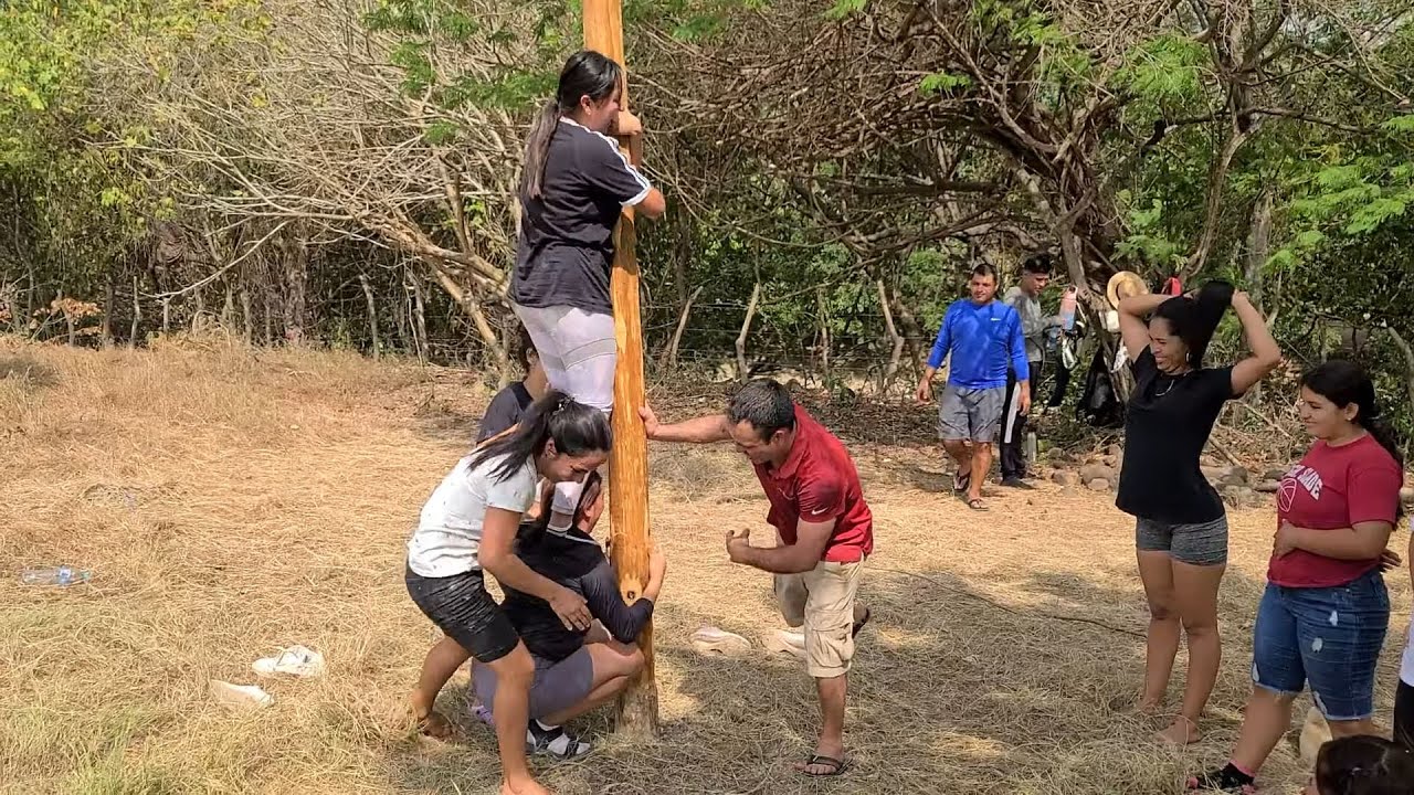 Luchando para subir el palo encebado😂Todos quiere ganar el gran premio.