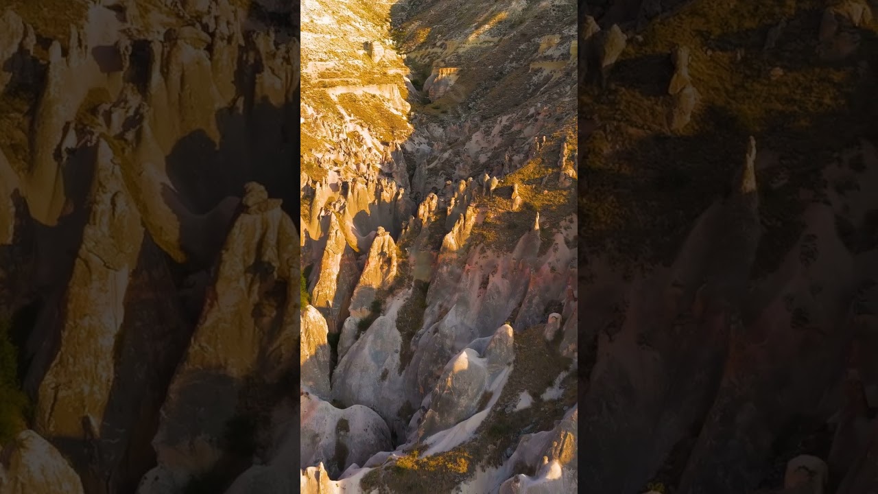 Vertical video. Goreme, Nevsehir, Turkey. Panoramic drone flight over Cappadocia valley at sunset...