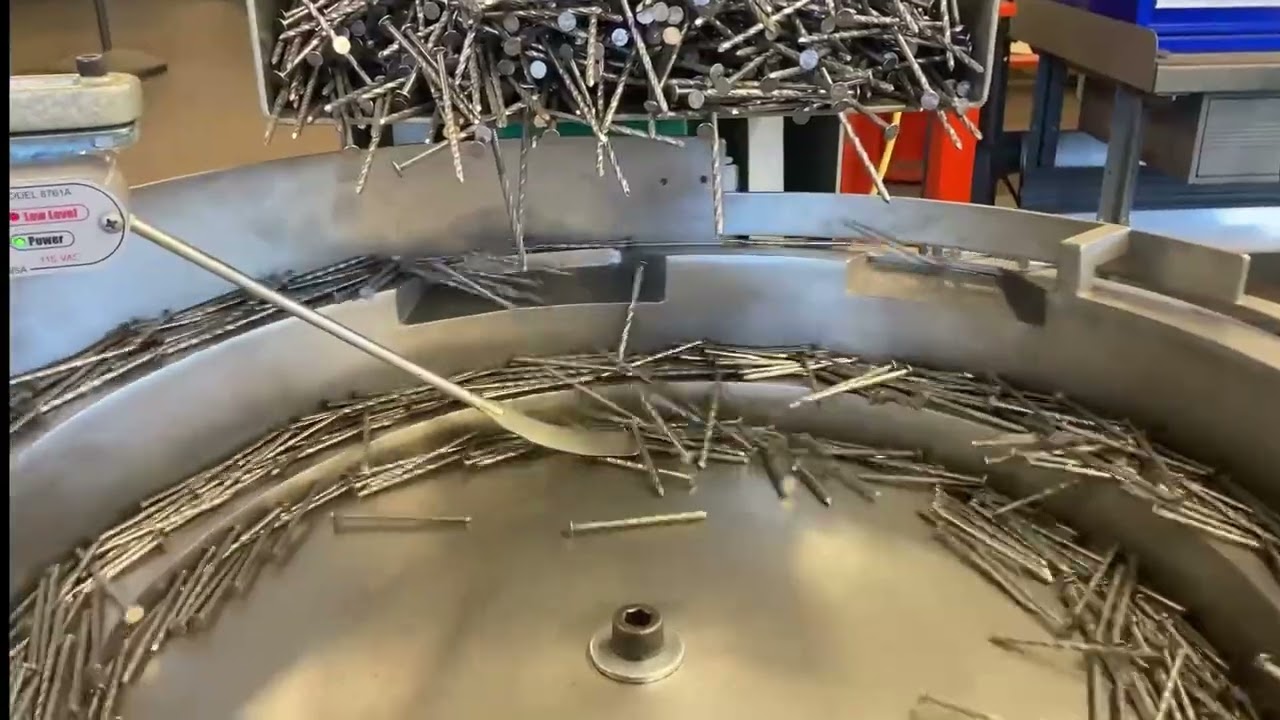 Orienting nails with a vibratory feeder system