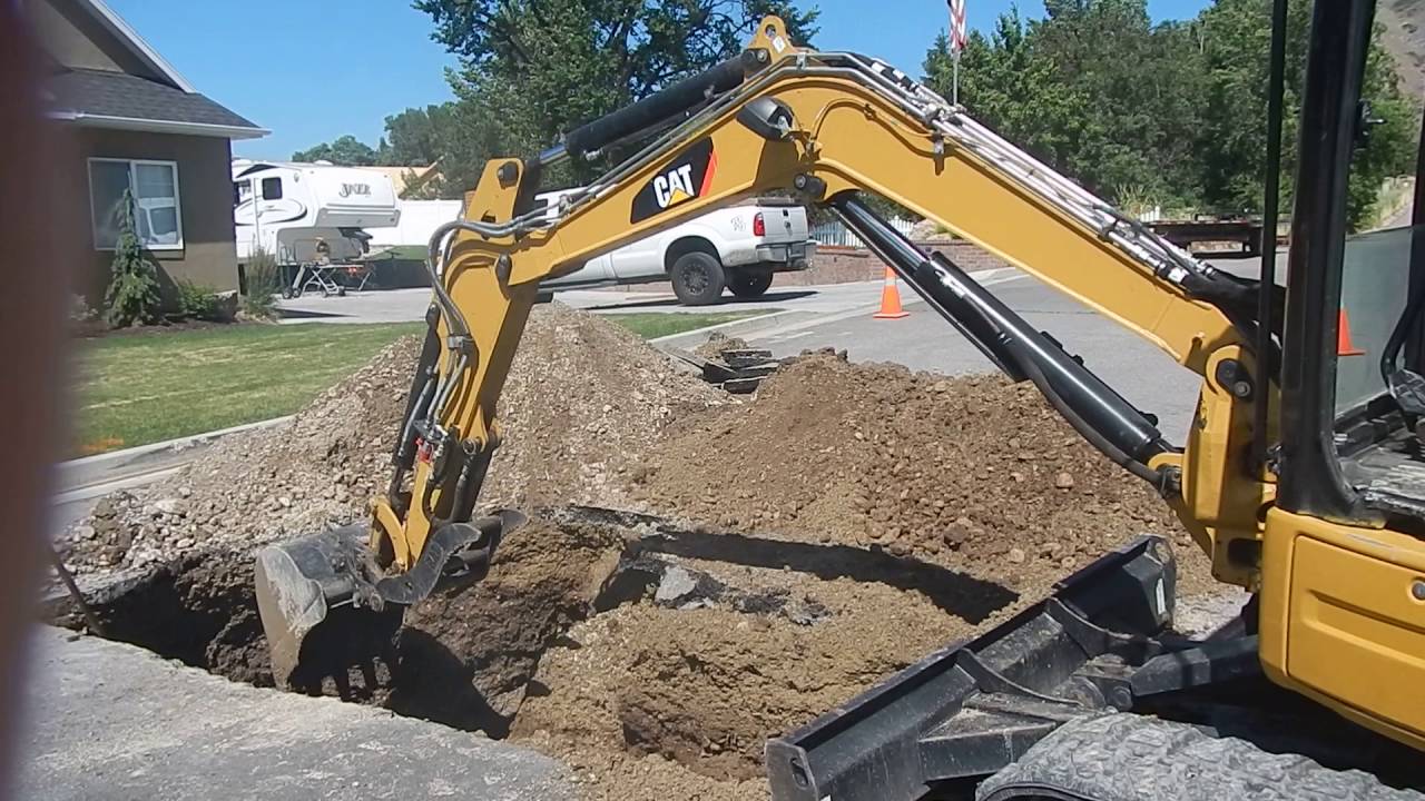Caterpillar 304E CR Excavator Digging In A Street . Fixing water leak.