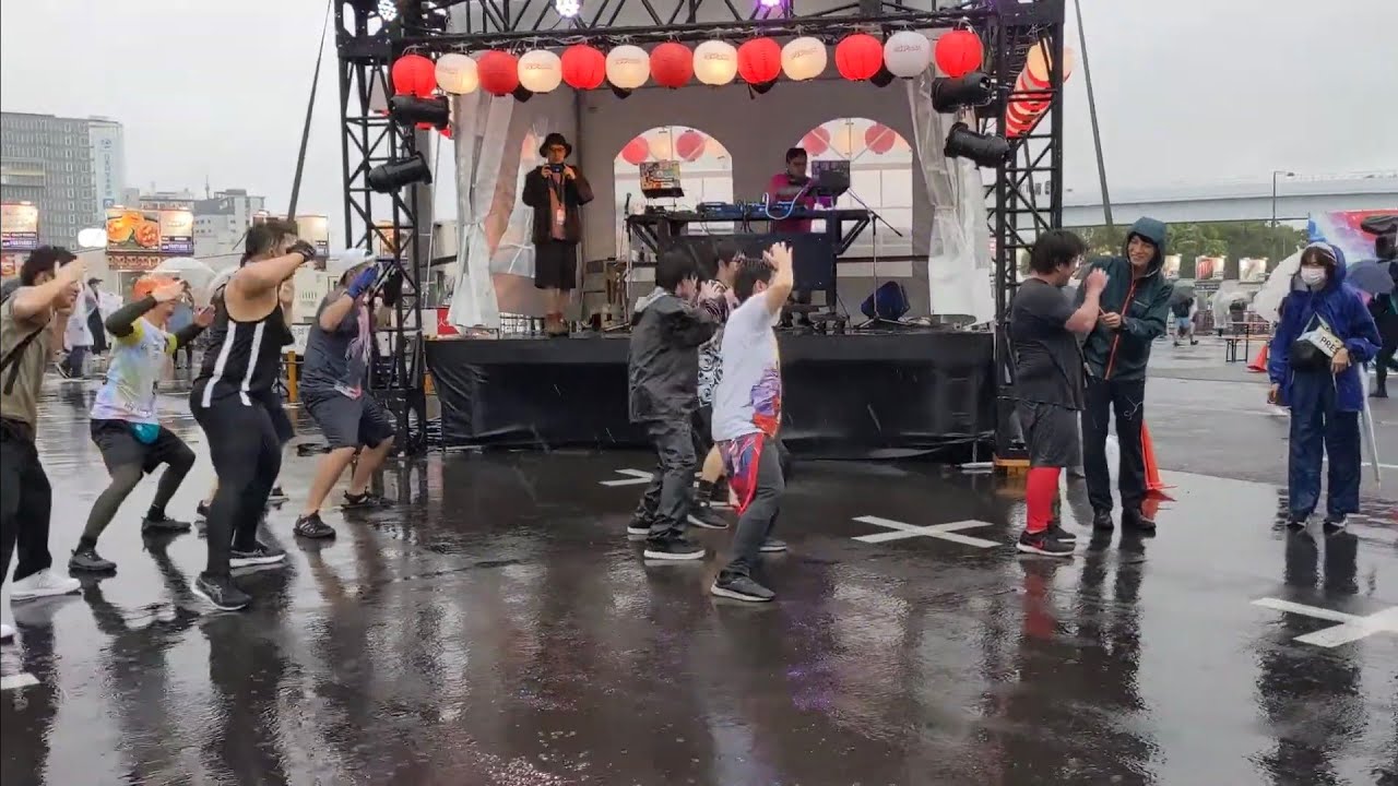 【#肉フェス 】#報道ステーション の取材を受けるオタクと後ろで踊るオタクたち #山切り部