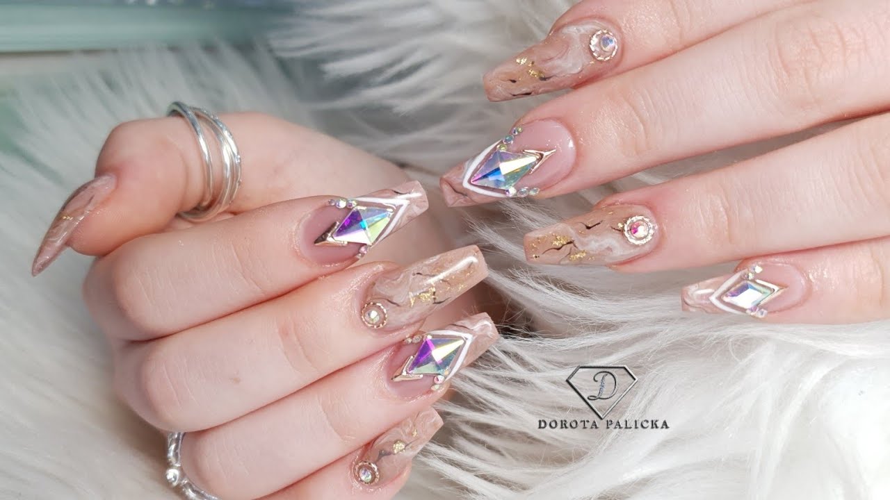 Gel nail extensions on tips with marble french and crystals placement