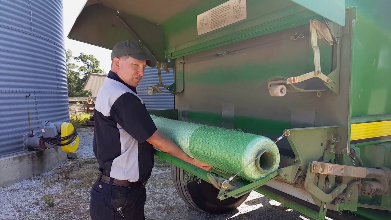 Загрузка нетканого полотна NetWrap в пресс-подборщик John Deere.