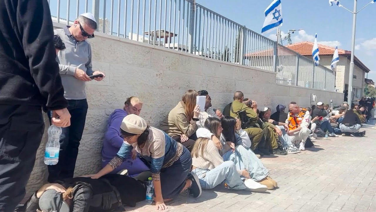 People take shelter during sirens at funeral of victims of Iranian strike on Israel | AFP