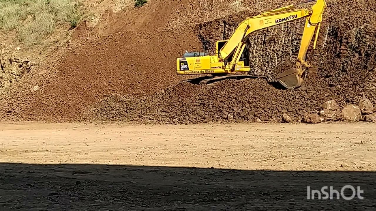 Escavadeira hidr&aacute;ulica soltando e carregando cascalho obra 60%cocluida