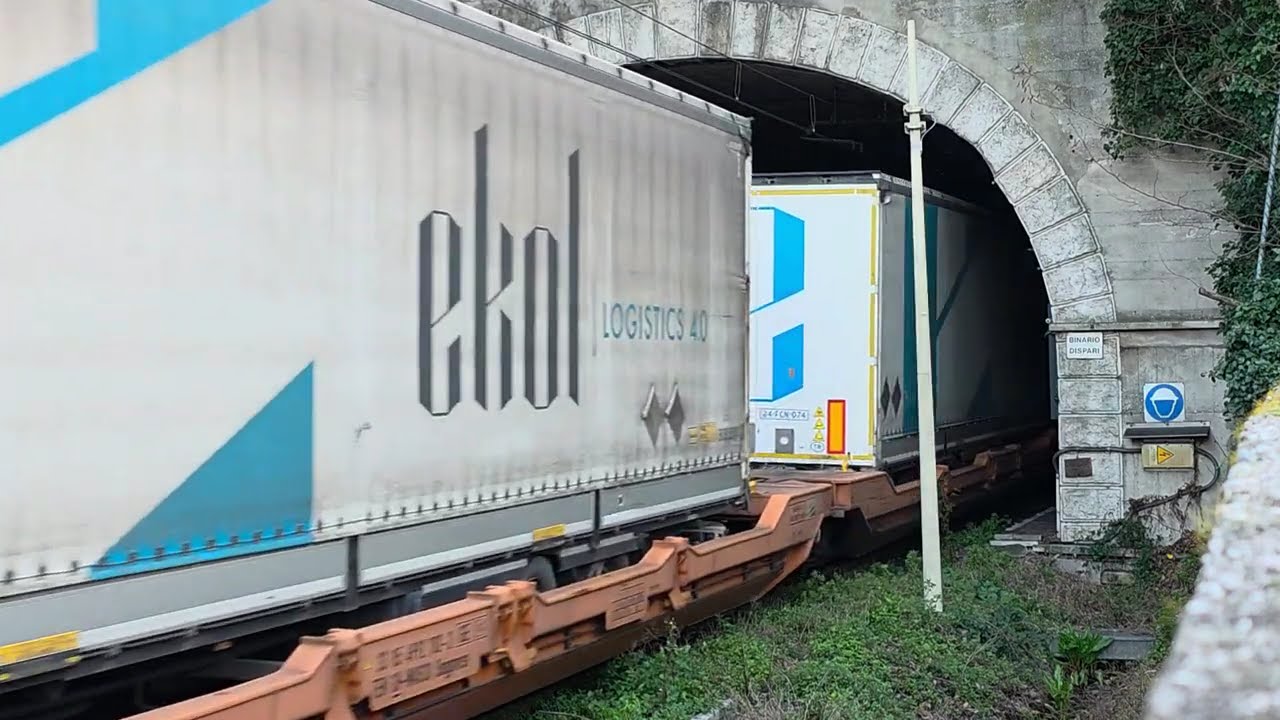 Il lungo convoglio intermodale capitanato da una Vectron total white in uscita dalla galleria