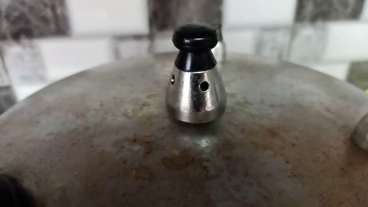 Pressure Cooker whistling with extreme close up of steams from the pressure valve.