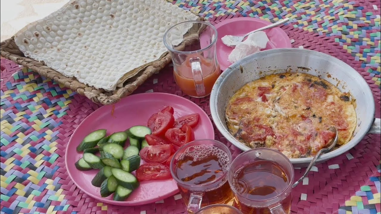 Having a traditional breakfast with tomato omelette in the heart of nature, by the river