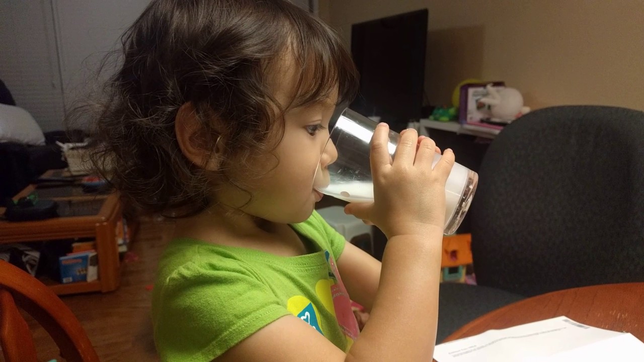 Baby Girl Drinks Milk From a Big Girl's Cup