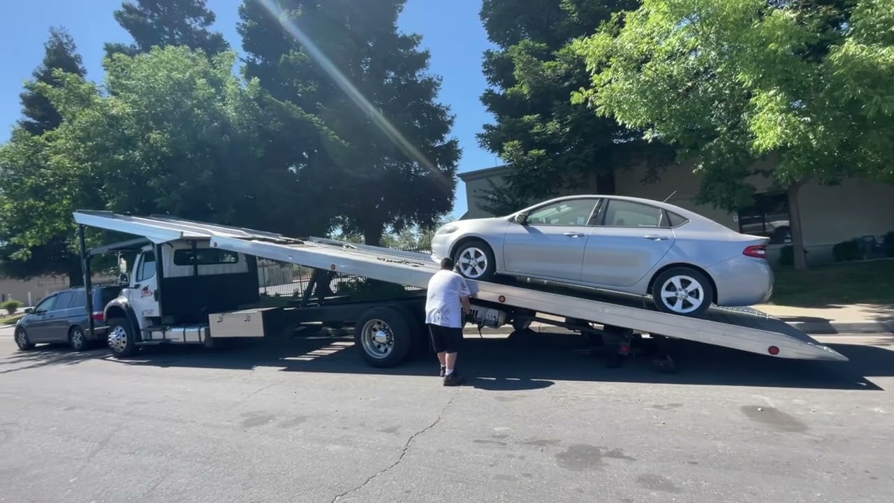 4 car rollback tow truck. Loading a non running car.