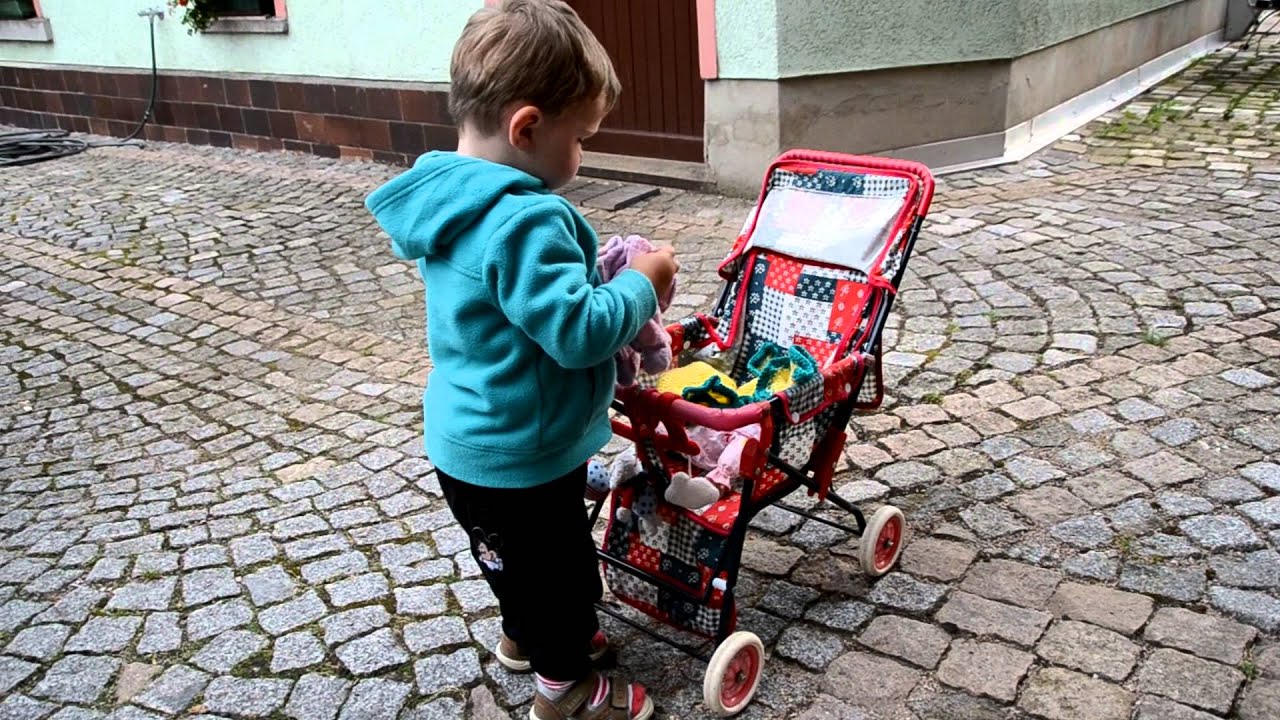 Kleiner Junge mit Puppenwagen