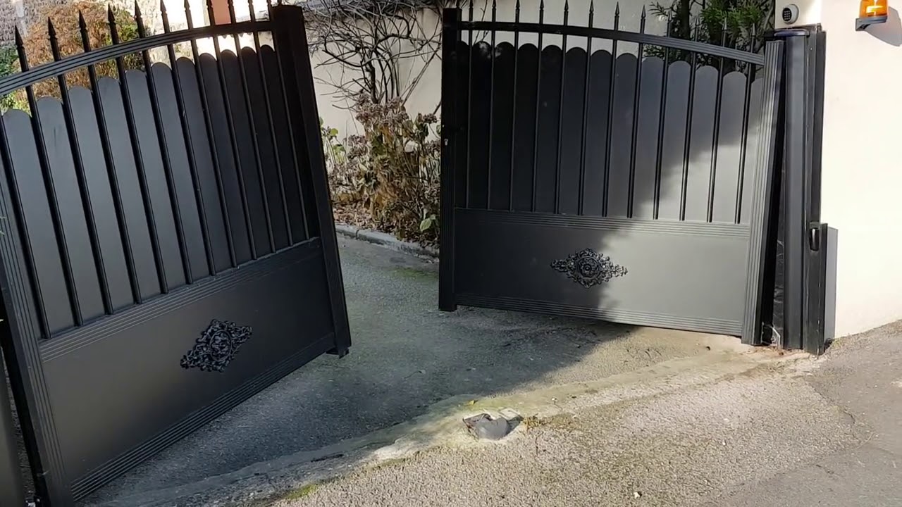 Portail battant motoris&eacute; pente vue ext&eacute;rieur