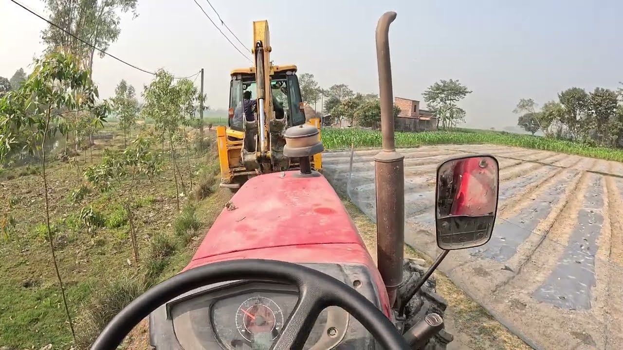 A JCB is working with many vehicles mixed together.