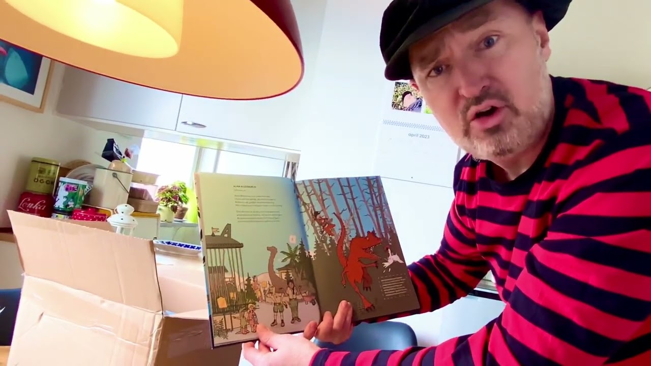 Pappa Kapsyl &ouml;ppnar paket med sin nya bok: Dinosauriernas Alfabet
