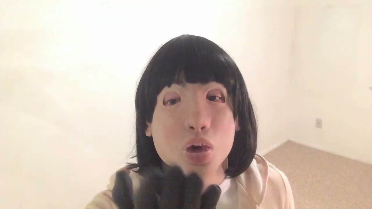 Crossdressing with female mask in tracksuit and wedge heel sneakers