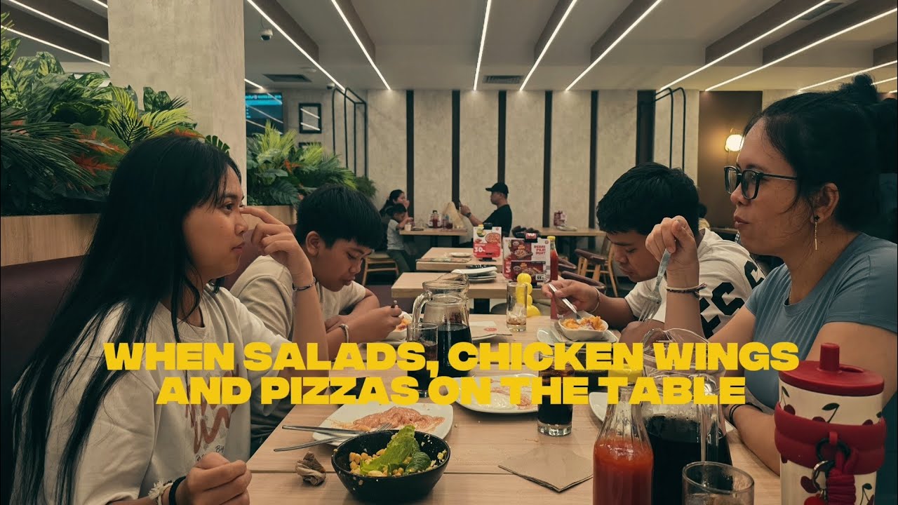 SALADS,CHICKEN WINGS & PIZZAS ARE ON TABLE.