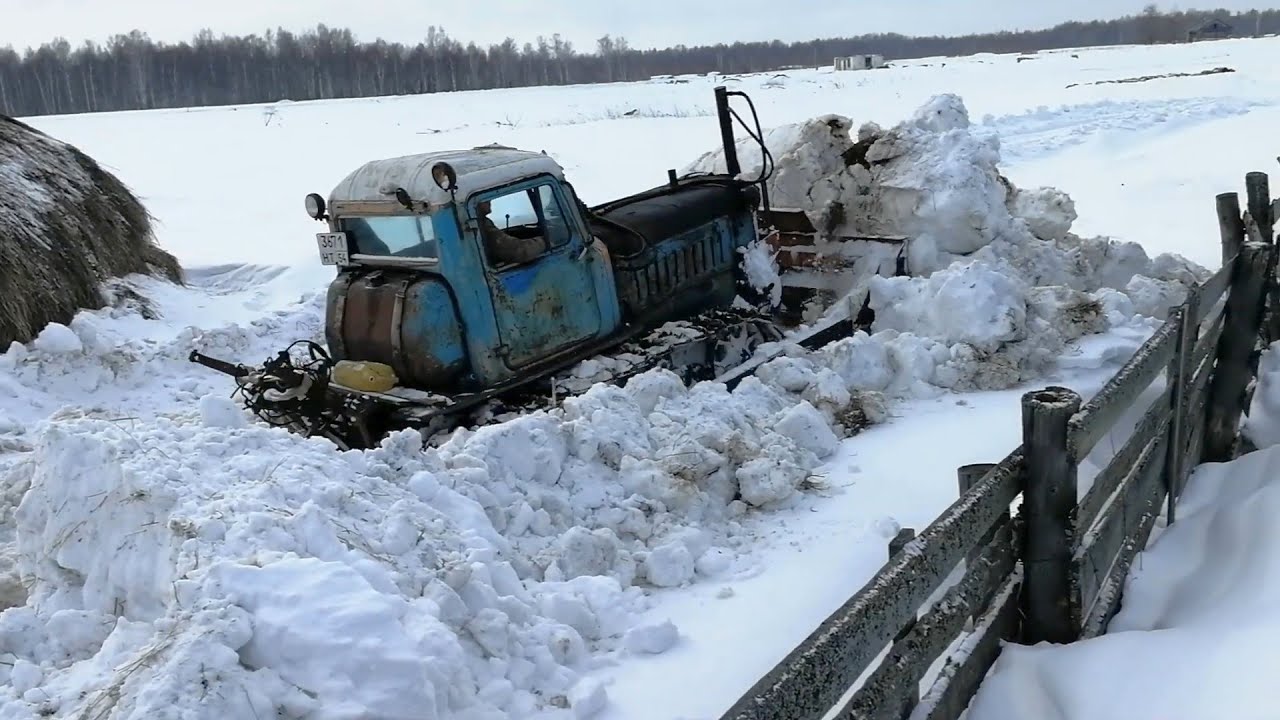 Старый  ДТ 75 разгребает снег.