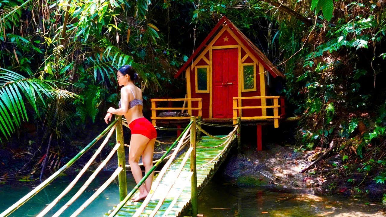 The girl builds a shelter and traps chickens in the rainforest to survive.