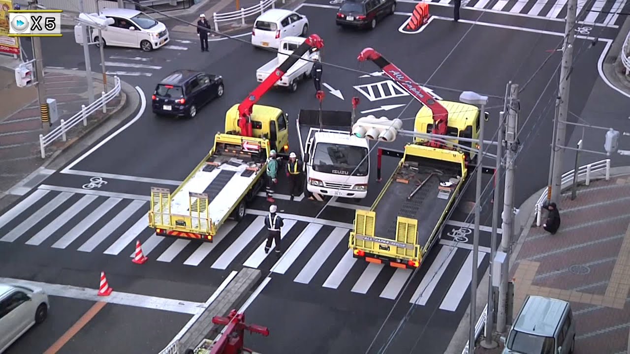 分離帯に乗り上げた事故車の撤去作業